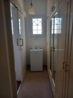 a bathroom with a washer and dryer and a window at Vasilis house in Mor Menekshe
