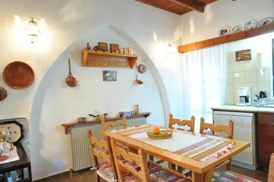 a dining room with a table and a kitchen at IRENE cottage in Kakopetria