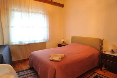 a bedroom with a bed with a red blanket and a window at IRENE cottage in Kakopetria