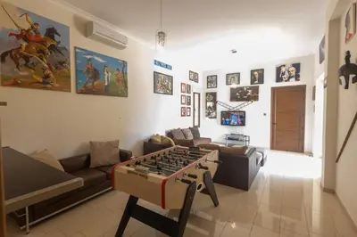 a living room with a couch and a foosball table in the middle at Sparta Luxury Villa in Protaras