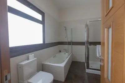 a bathroom with a toilet and a bath tub at Sparta Luxury Villa in Protaras