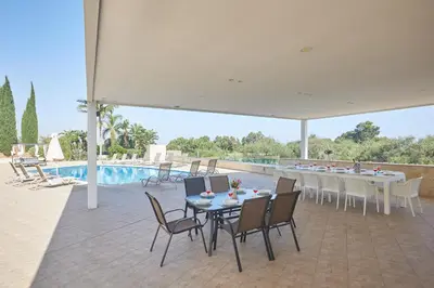 a patio with a table and chairs and a pool at Sparta Luxury Villa in Protaras