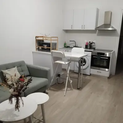 a living room with a couch and a table and a kitchen at Maison Zenon Larnaca City Center apartments in Larnaka