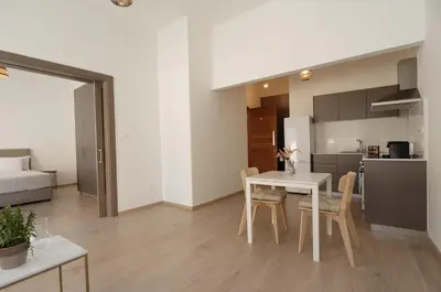 a kitchen and dining room with a white table and chairs at Maison Zenon Larnaca City Center apartments in Larnaka