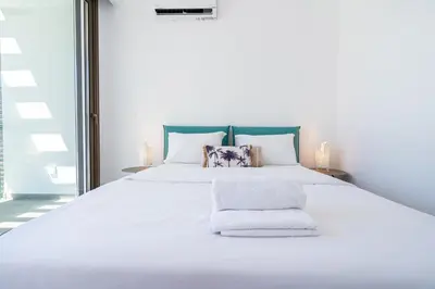 a large white bed with white sheets and pillows at Waves 3-Bedroom Villa in Protaras in Paralimni