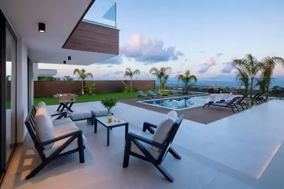 a patio with a pool and chairs and a table at The Oasis in Protaras