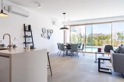 a kitchen and living room with a table and chairs at Cyan 3-Bedroom Villa in Protaras in Paralimni