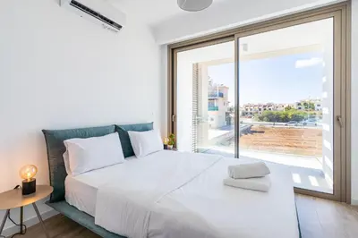 a bedroom with a large white bed and a large window at Cyan 3-Bedroom Villa in Protaras in Paralimni
