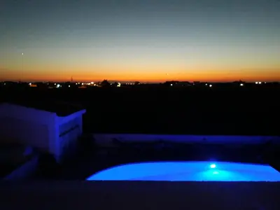 a view of a sunset from a balcony with a blue pool at Liopetri 2-Bed Apt Sleeps 6 Pool 10min to Beach in Liopetri