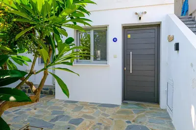 a black garage door on a white house at The MedView Garden House in Pervolia