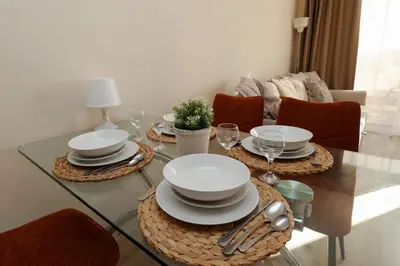 a dining room table with plates and glasses on it at Nissi 3 C14 Sea View Top Floor Apartment in Ayia Napa