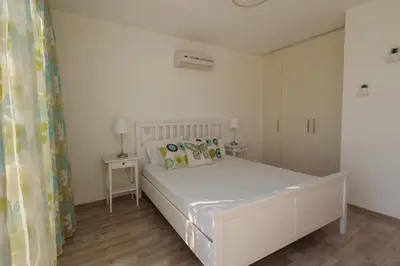 a white bedroom with a bed and a mirror at Nissi 3 C14 Sea View Top Floor Apartment in Ayia Napa
