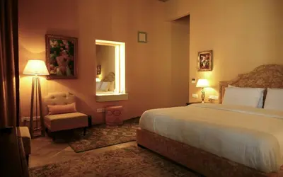 a bedroom with a bed and a chair and a mirror at Madama Residence in Nicosia