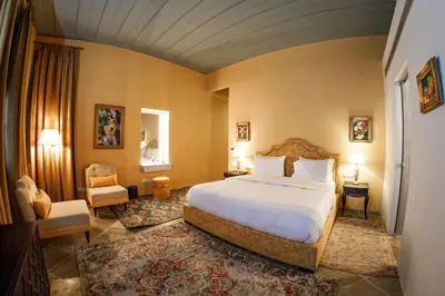 a bedroom with a large bed and a chair at Madama Residence in Nicosia