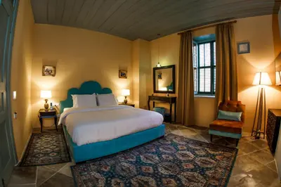 a bedroom with a large bed and a chair at Madama Residence in Nicosia