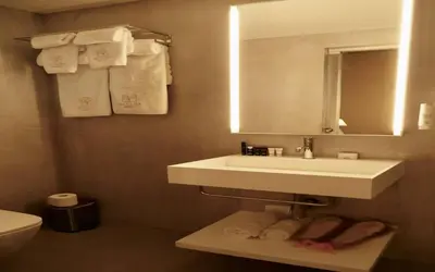 a bathroom with a sink and a mirror and towels at Madama Residence in Nicosia