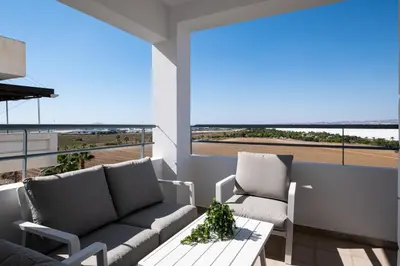 a living room with couches and a table and a large window at The Saline Views Makenzy in Larnaka