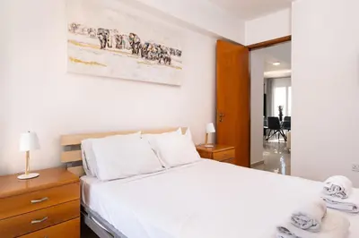 a bedroom with a large bed with white sheets and towels at The Saline Views Makenzy in Larnaka