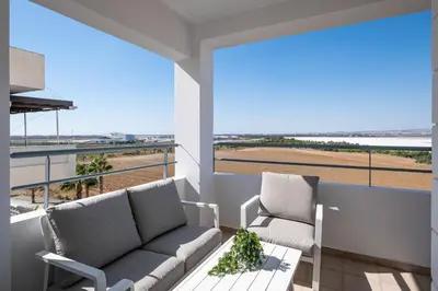 a balcony with two couches and a view of a field at The Saline Views Makenzy in Larnaka