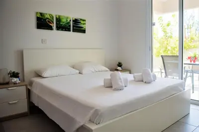 a white bed with two pillows on it in a bedroom at Carme at the Beach - Mythical Sands in Paralimni
