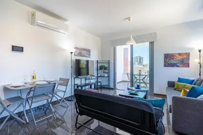 a living room with a couch and a table at Kmeidos 1-Bedroom Apartment in Larnaca in Larnaka