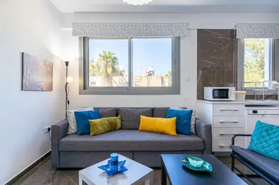a living room with a couch and a table at Kmeidos 1-Bedroom Apartment in Larnaca in Larnaka