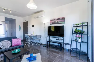 a living room with a couch and a tv at Kmeidos 1-Bedroom Apartment in Larnaca in Larnaka