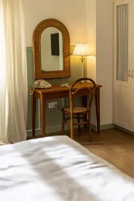 a bedroom with a desk with a mirror and a chair at The Agora Hotel - Small Luxury Hotel of the World - Adults Only in Pano Lefkara