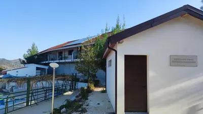 a white building with a brown door next to a building at Limeria in Alona