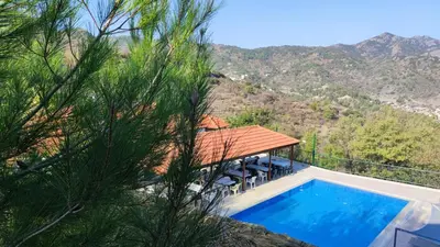 a house with a swimming pool next to a mountain at Limeria in Alona
