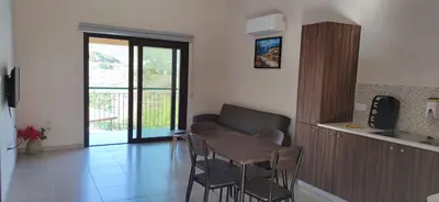a kitchen with a table and chairs in a room at Limeria in Alona