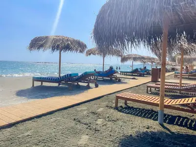 a beach with many chairs and umbrellas and the ocean at Samson Sea Breeze, 3bed sleeps 6, free WiFi in Limassol