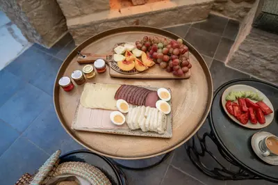 a table with a plate of food and fruit on it at Palazzino Luxury Suites in Lofou
