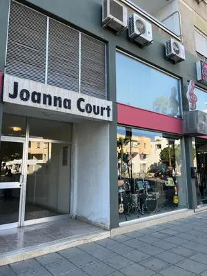 a jomaina court sign on the facade of a store at Joanna Court rooms in Larnaka