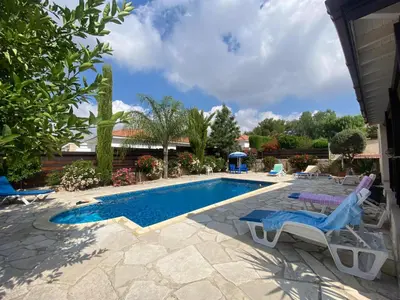 a swimming pool with lounge chairs next to a house at LE CAROUBIER splendid 3 bedrooms bungalow in Zanaja