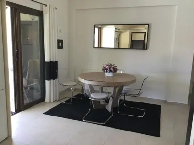 a table and chairs in a room with a mirror at LE CAROUBIER splendid 3 bedrooms bungalow in Zanaja