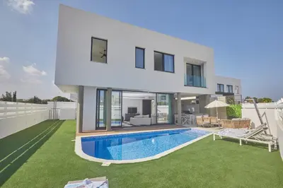 a villa with a swimming pool and a house at Almaria Villas in Protaras