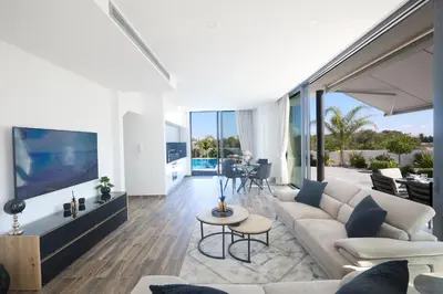 a living room with a couch and a tv at Almaria Villas in Protaras