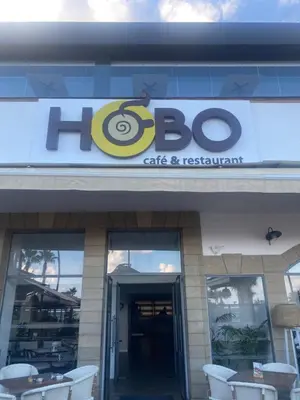a building with a sign for a cafe and restaurant at Raam Luxury Suites in Larnaka