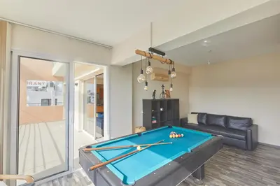 a living room with a pool table and a couch at Spectacular Sea View, private jacuzzi & table pool in Protaras