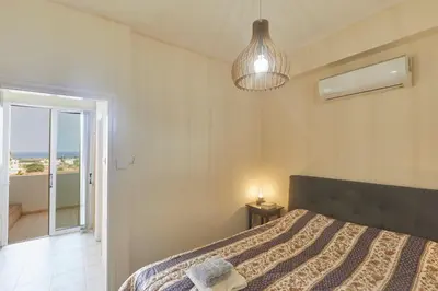 a bedroom with a bed and a pendant light at Spectacular Sea View, private jacuzzi & table pool in Protaras