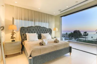 a bedroom with a bed with a large window at Palace of Mediterranean Beachfront Villa in Ayia Napa