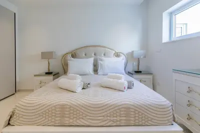 a large white bed with two pillows on it at Palace of Mediterranean Beachfront Villa in Ayia Napa