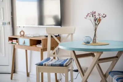 a table and a chair with a vase on it at Pissouri bay studio in Pissouri