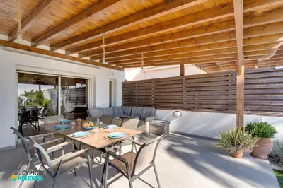a dining room with a table and chairs on a patio at Beachfront Villa Carpe Diem in Mor Menekshe