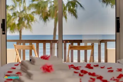 a table with a wedding cake with red roses on it at Beachfront Villa Carpe Diem in Mor Menekshe