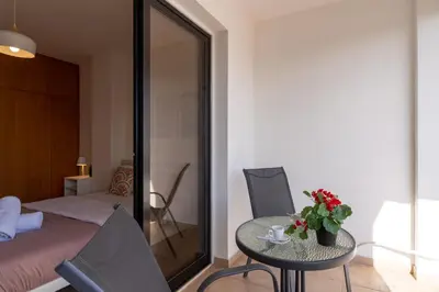 a room with a table and chairs and a bed at Polyn 1- Bedroom Apartment in Larnaca in Larnaka