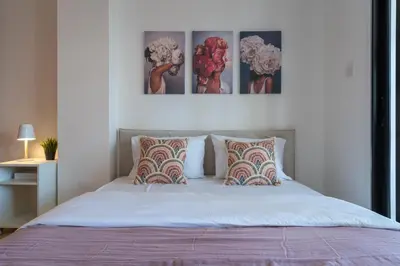 a bedroom with a bed with four pictures on the wall at Polyn 1- Bedroom Apartment in Larnaca in Larnaka