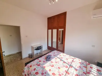 a bedroom with a bed and a table in it at Luxury City Rooms - Smart TV with Netflix in Larnaka
