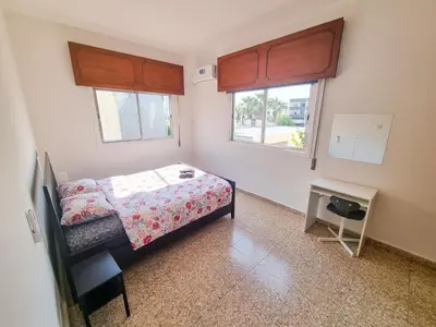 a small bedroom with a bed and two windows at Luxury City Rooms - Smart TV with Netflix in Larnaka